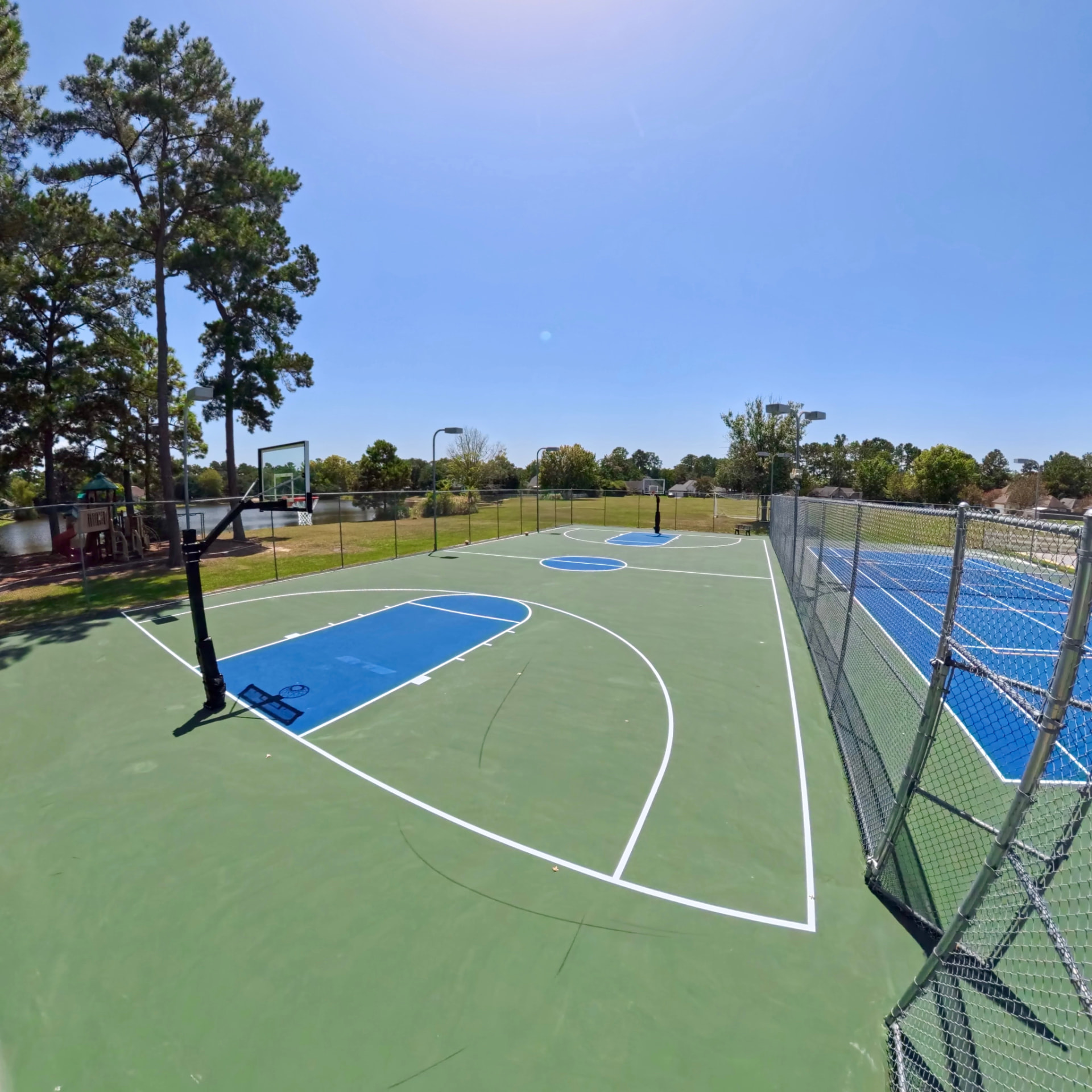 Basketball court with the playground and pond behind it