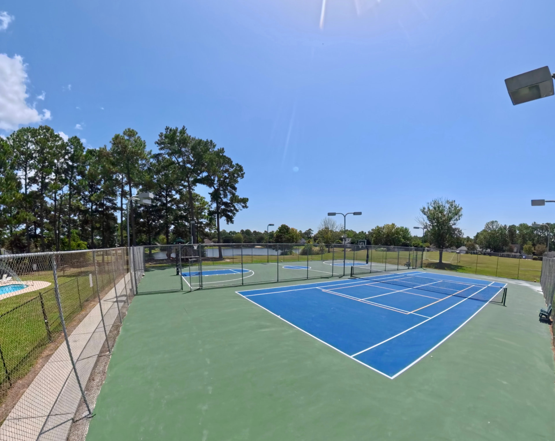 Overview of the sports courts with the pond in the background