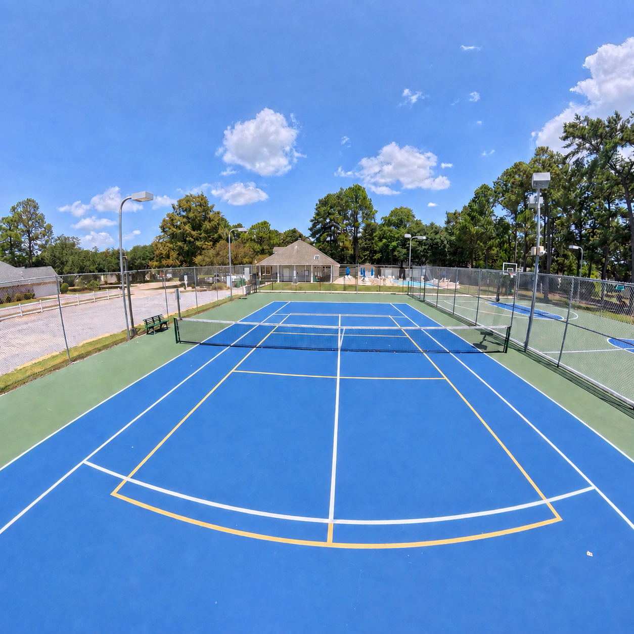 Tennis court with pickleball lines and adjacent basketball court